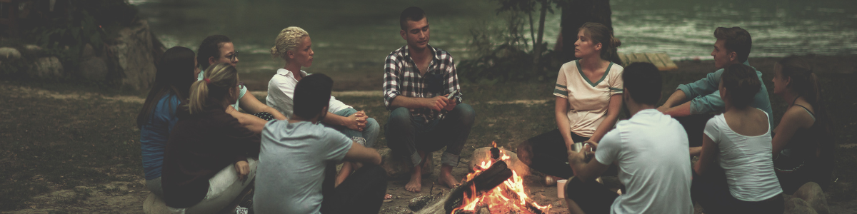 Seminare und Gruppenarbeit – Gemeinschaft und Selbsterfahrung Teilnehmende eines Gruppenseminars sitzen gemeinsam um Lagerfeuer in der Natur
